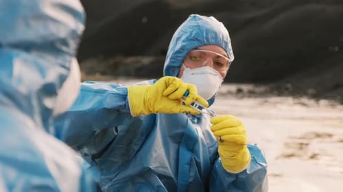 Scientists in Hazmat Suits Examine Test Tube