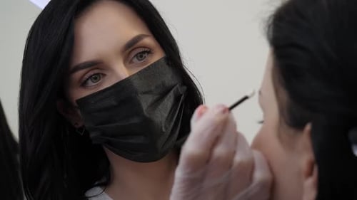 Beautician Shaping Eyebrows with Brush Close Up