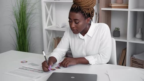 Woman at Desk Works on Financial Data