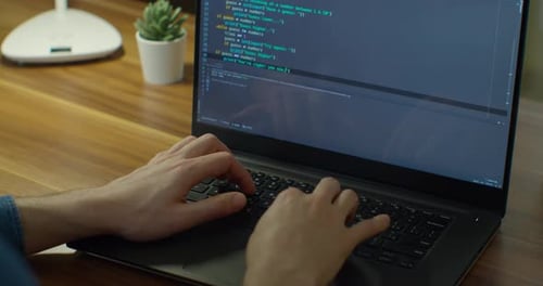 De cerca: ingenieros desarrollan una Aplicación de software utilizando un ordenador portátil digital que escribe el código en la pantalla