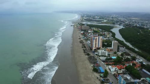 Vista aérea, seguindo uma praia com muitas ondas