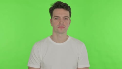 Thumbs Down By Young Man on Green Background