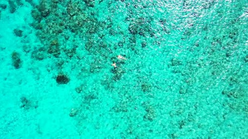 Luxury overhead tourism shot of a sandy white paradise beach and turquoise sea background in colorfu