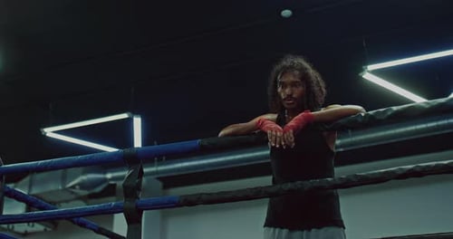 Boxer Leans Against Ropes in Ring, Low Angle