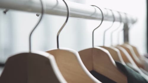 Clothes Hanging on Hangers in Closet