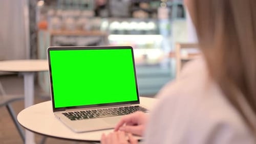 Woman Looking at Laptop with Green Chroma Key Screen Rear View