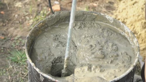 Mixing Wet Cement Inside a Metal Bucket