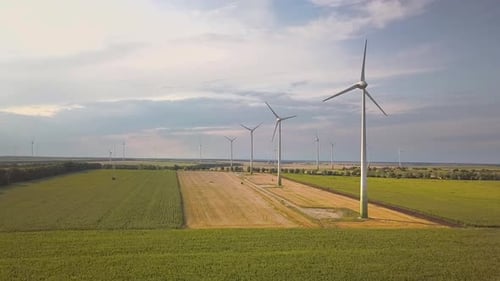 Aerial view of wind turbine generators in field producing clean ecological electricity.