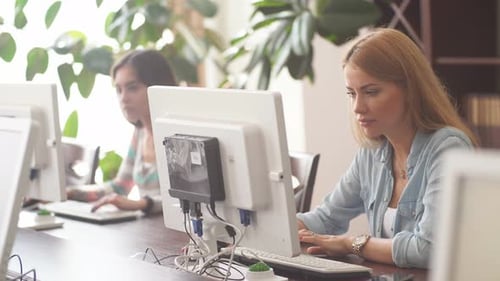 Caucasian Woman Using Personal Computer To Browse the Net in Office Library