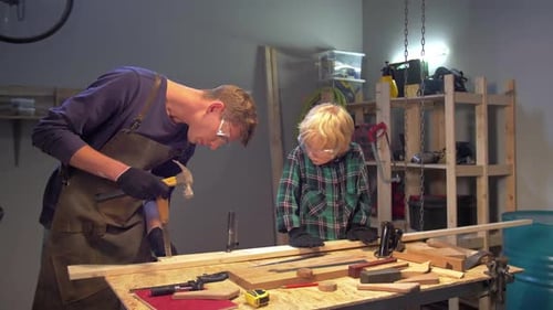 Man Shows Boy How To Work with Wood in a Workshop