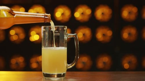 Beer Pours into Glass Mug at a Bar