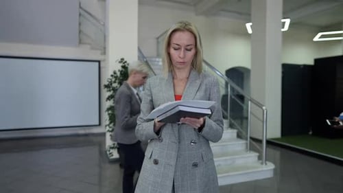 Business Woman Checking Notebook in Office Lobby
