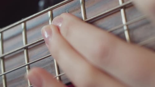 Female Holding An Acoustic Bass Guitar and Play Music Solo Close Up