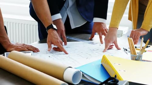 Team Collaborating on Blueprint in Office Environment