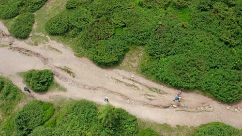 A Topdown Aerial View of Young People Walking Along a Mountain Trail to the Top of the Mountain