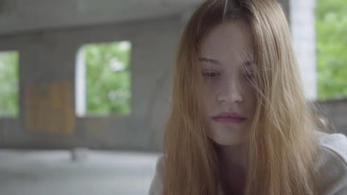 Portrait of Caucasian Young Sad Girl Sitting in an Abandoned Building Having Drug Breaking