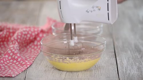 Electric Mixer Blends Baking Ingredients in Glass Bowl