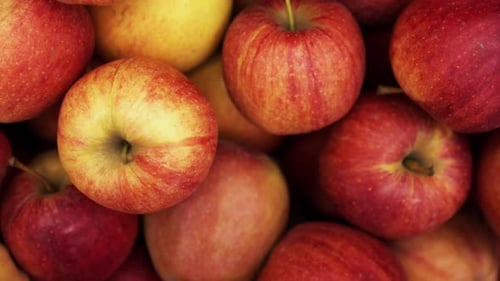 Many Red Apple Closeup Rotating on a Background in Store for Buyer.