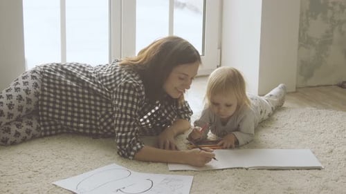 Woman and Child Drawing Together on Floor