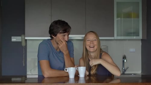 Man and Woman Laughing Together in Kitchen