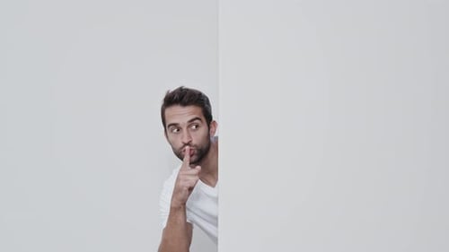 Man Behind Wall Peeking and Making Shush Gesture