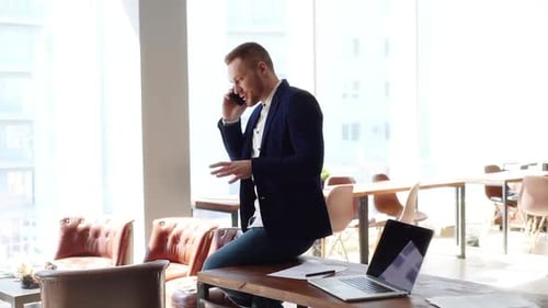 Stylish Young Adult Talking on Cell Phone in Office