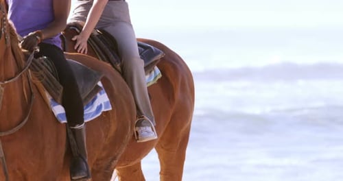 People riding horse on beach
