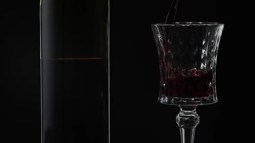 Pouring Red Wine into Glass on Black Background