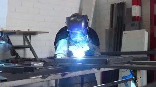Factory male worker producing metal construction