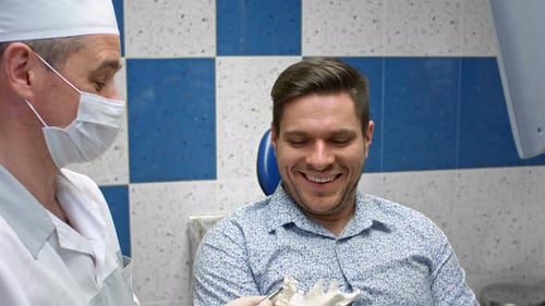 Dentist Explains Teeth Model to Patient in Clinic
