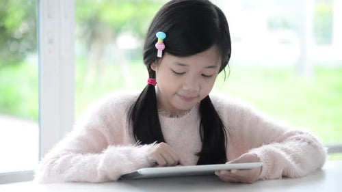 Beautiful Asian Girl Using Tablet On White Table