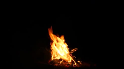 Brennendes Lagerfeuer auf schwarzem Hintergrund mit hell ausbrechenden Funken