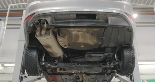 Car Undercarriage on Lift in Auto Repair Shop
