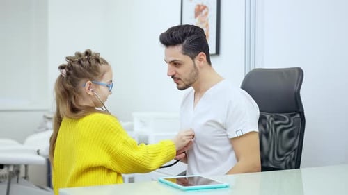 Pretty Girl in Eyeglasses Using Stethoscope Listening Auscultation of Positive Doctor in Hospital