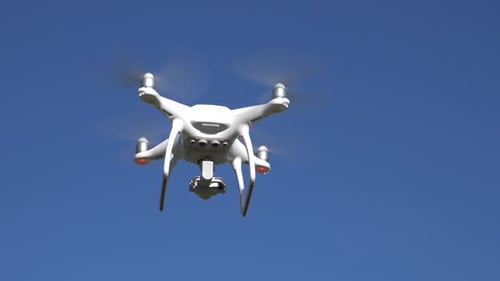 Drone Hovering in Clear Blue Sky