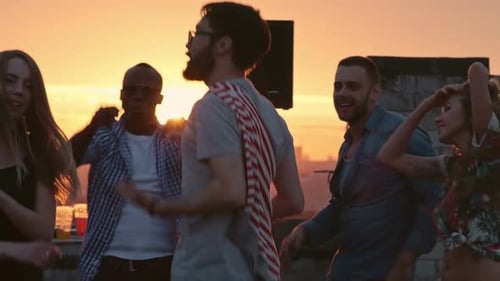 People Dancing at Rooftop Party at Sunset