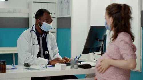 Pregnant Woman Consults Doctor in Medical Office