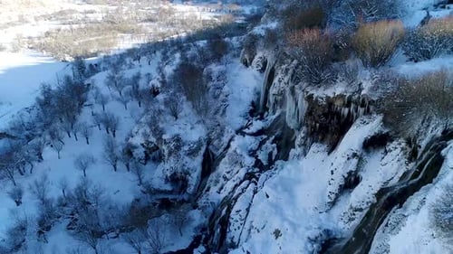 Aerial View of Snowy Waterfall and Winter Landscape
