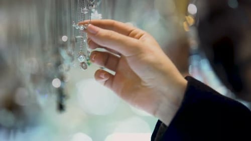 Female Hand Holding Diamond Pendant, Jewelry Assortment in Luxury Shopping Mall