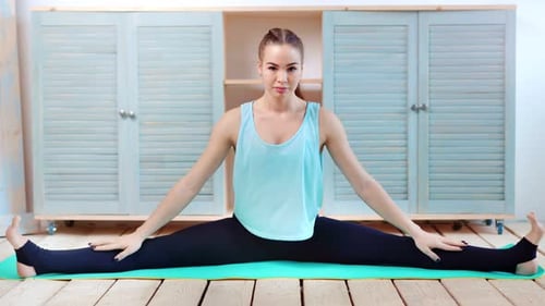 Flexible Young Fit Woman Sitting on Mat in Twine and Making Stretching Full Shot
