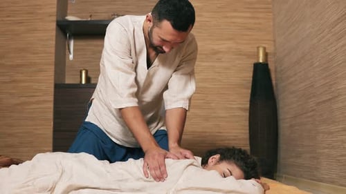 Man Giving Relaxing Back Massage to Woman