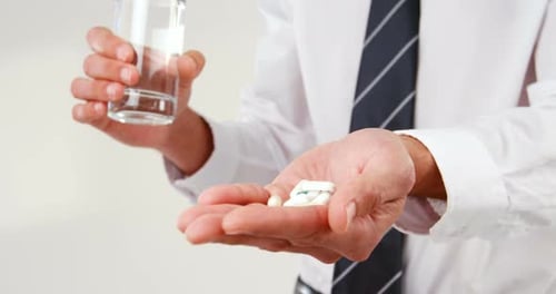 Mid-section of man taking pill