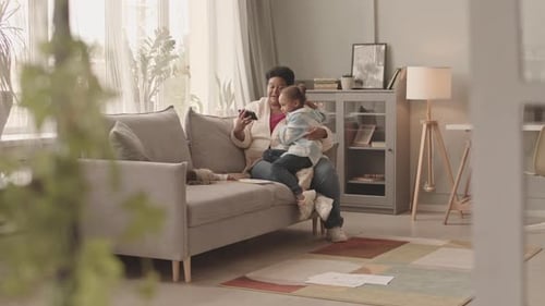 Mother and Daughter Looking at Smartphone on Sofa