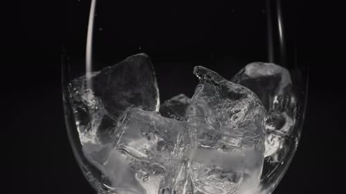 Liquid Poured Over Ice Cubes in Clear Glass