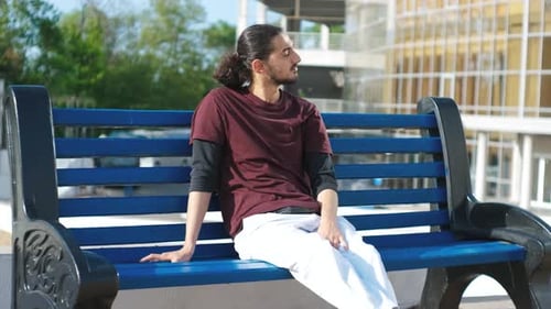 Coseup Portrait of Handsome Arab Man Sitting on a Bench in the Park
