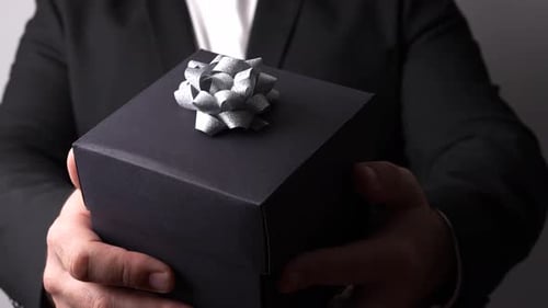 Man Holding Gift Box with Silver Bow