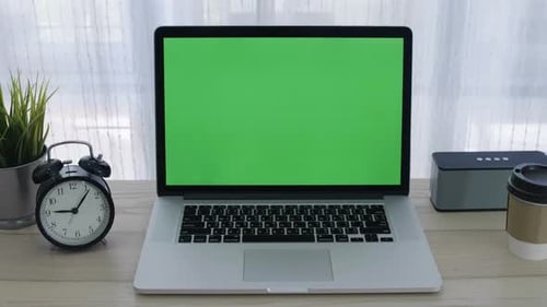 Chroma key green screen of laptop computer set on working space in home office