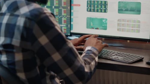 Consultor financiero que utiliza varios monitores para crear un plan de cambio de divisas
