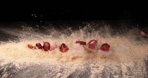Garlic, allium savitum, Garlic pawns Falling on Garlic Powder on Black Background,, Slow Motion 4K