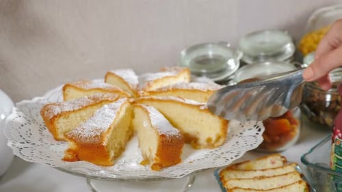 Servieren Sie ein Stück köstlichen Kuchen auf dem Teller mit einer kulinarischen Zange im Hotel. Frisches leckeres Gebäck